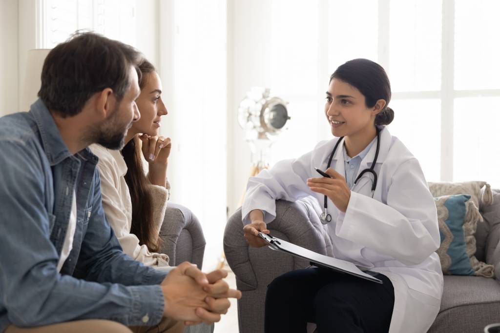 A young, Indian doctor speaks to a couple about ART options.