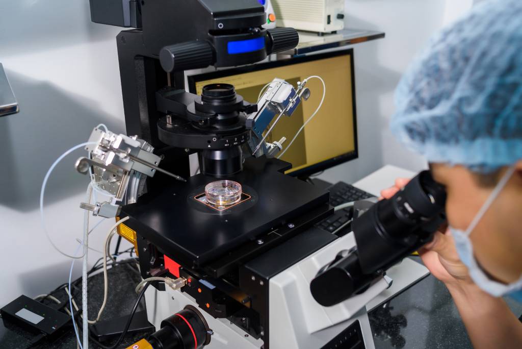 An OB-GYN practicing IVF techniques in a lab setting.