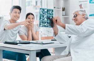 A doctor shows an overjoyed couple their first ultrasound post successful embryo transfer.